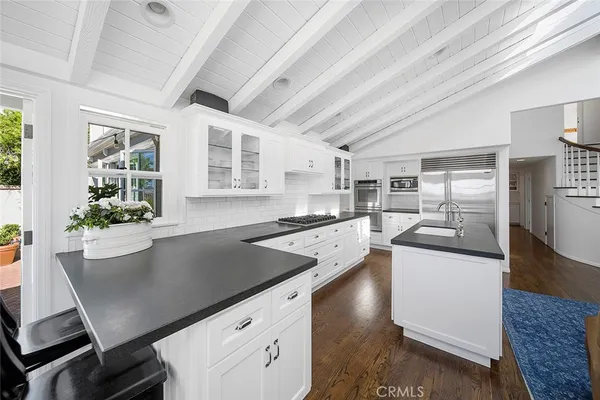 a kitchen with stainless steel appliances granite countertop a sink a stove and a refrigerator