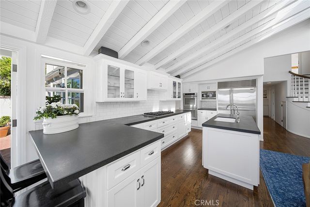 a kitchen with stainless steel appliances granite countertop a sink a stove and a refrigerator