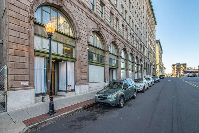 a couple of cars parked in front of brick building