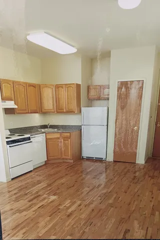 a kitchen with a refrigerator and a stove top oven