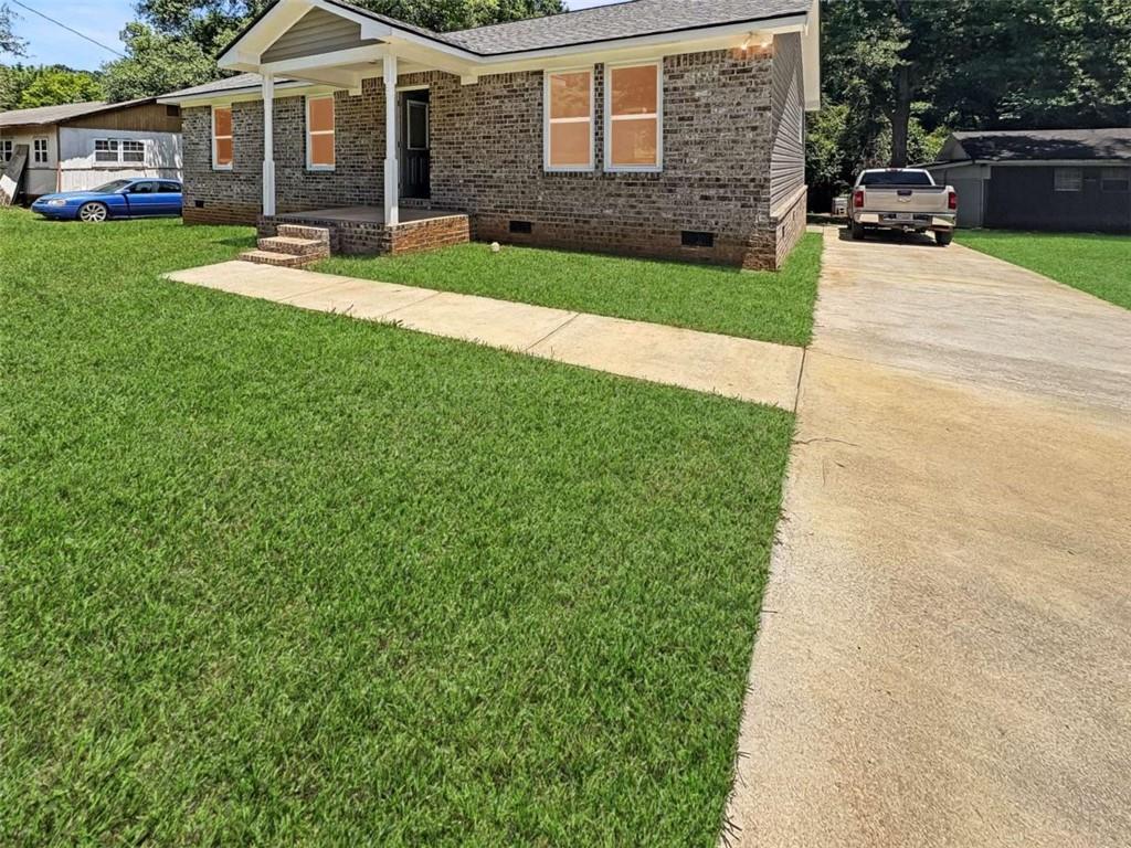 24 George Street Forsyth, GA 31029 - Photo 3 of 17 a front view of a house with a yard and trees