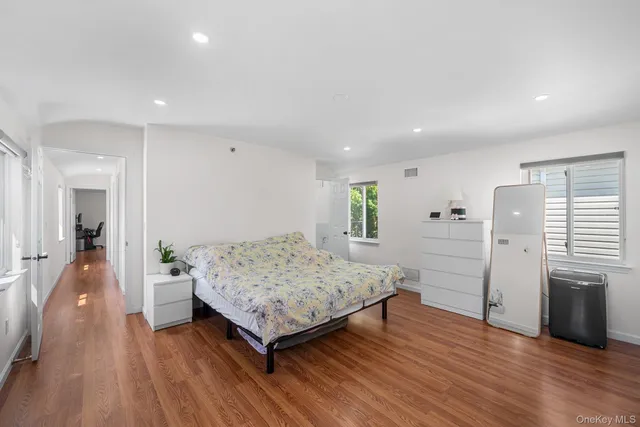 a spacious bedroom with a bed and a flat screen tv