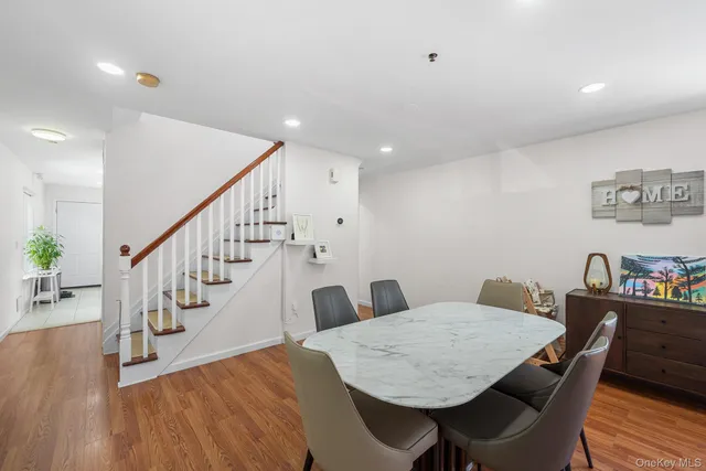 a view of a dining room with furniture a rug and wooden floor