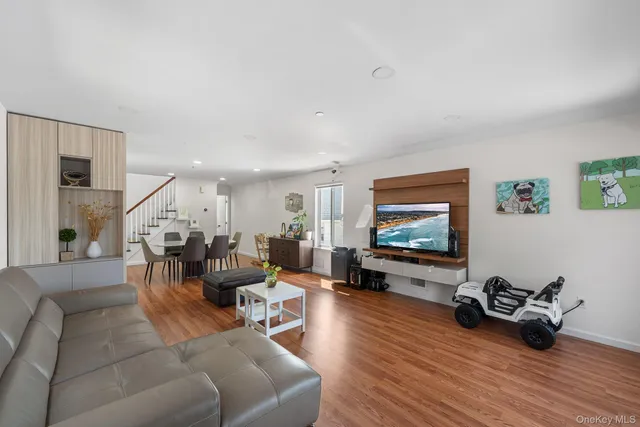 a living room with furniture wooden floor and a flat screen tv