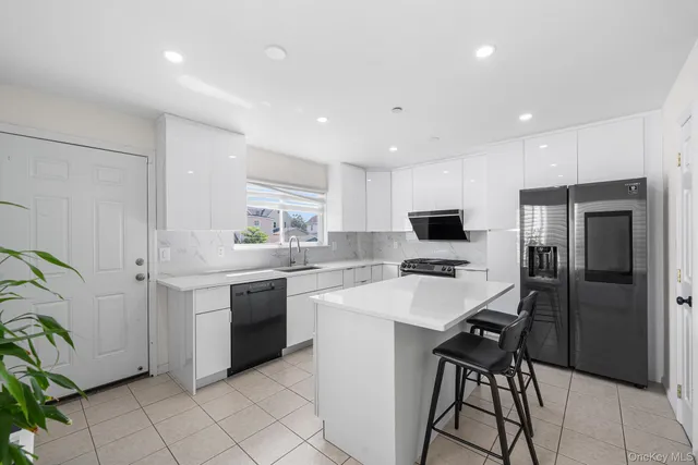 a kitchen with a sink stainless steel appliances and white cabinets