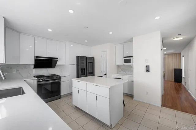 a kitchen with white cabinets and stainless steel appliances