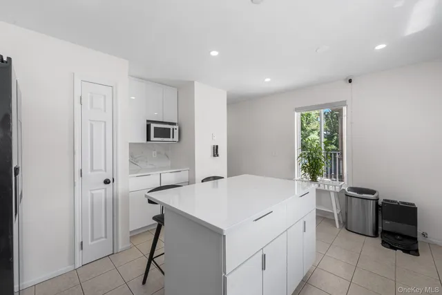 a room with a bed and a view of kitchen