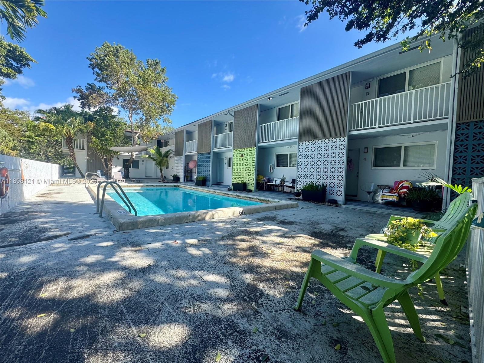 6805 Southwest 88th Street, Unit 12 Pinecrest, FL 33156 - Photo 2 of 18 a view of a backyard with table and chairs potted plants and a large tree