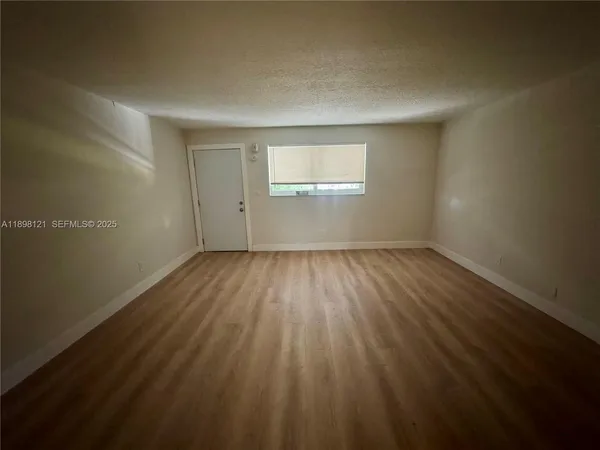 a view of a room with wooden floor and windows