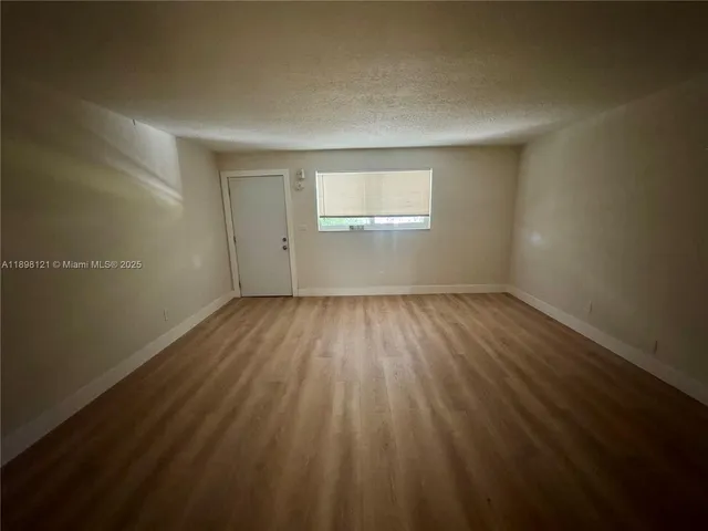 a view of a room with wooden floor and windows