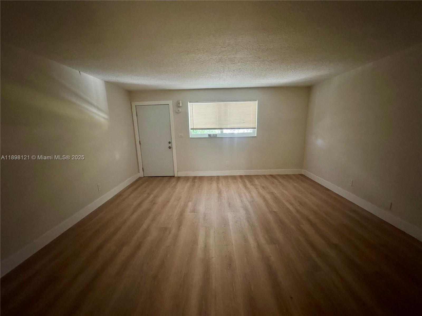 6805 Southwest 88th Street, Unit 12 Pinecrest, FL 33156 - Photo 6 of 18 a view of a room with wooden floor and windows