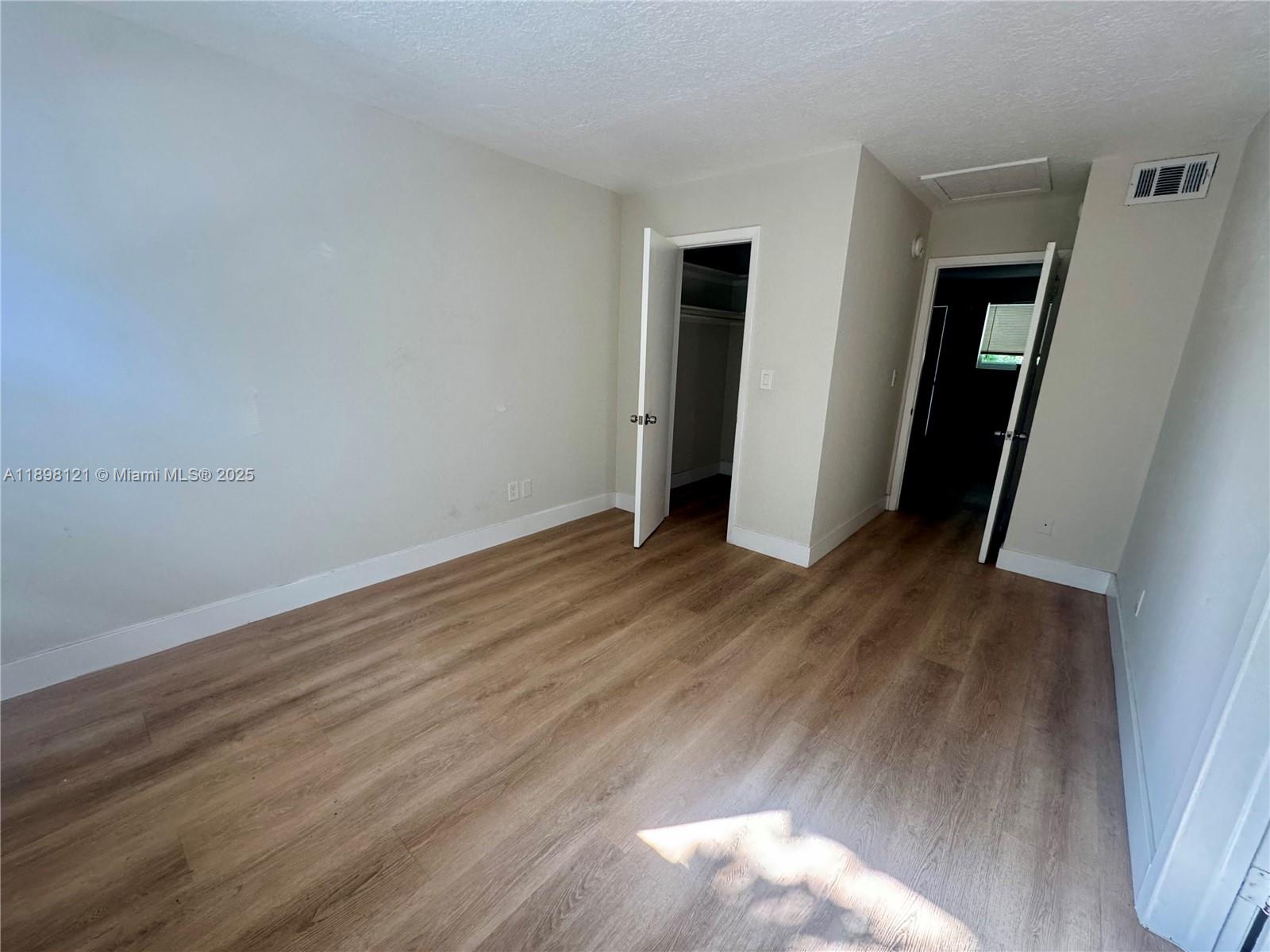6805 Southwest 88th Street, Unit 12 Pinecrest, FL 33156 - Photo 10 of 18 an empty room with wooden floor and closet