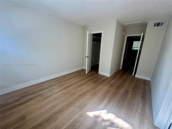 an empty room with wooden floor and closet