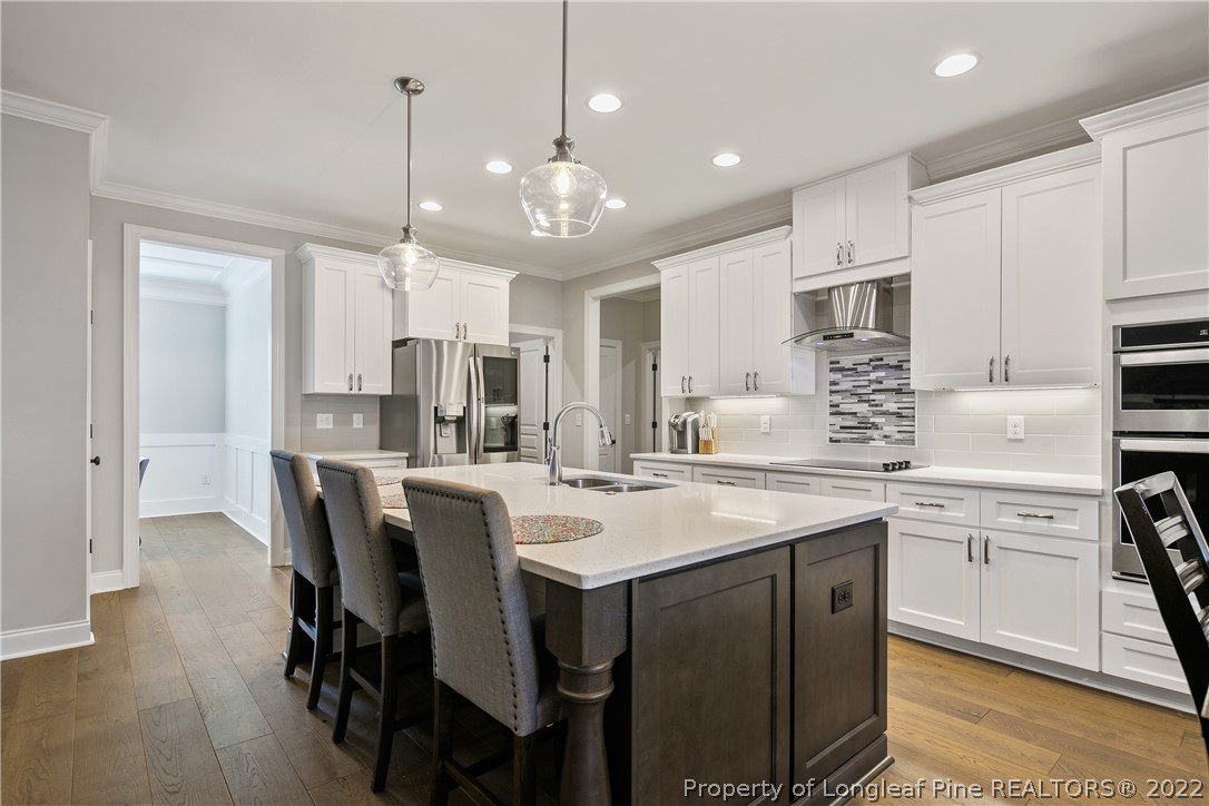 46 Brookhill Court Spring Lake, NC 28390 - Photo 15 of 50 a large kitchen with kitchen island granite countertop a table chairs sink and cabinets