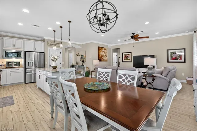 a kitchen with granite countertop a stove a sink a kitchen island with stainless steel appliances cabinets and a wooden floor