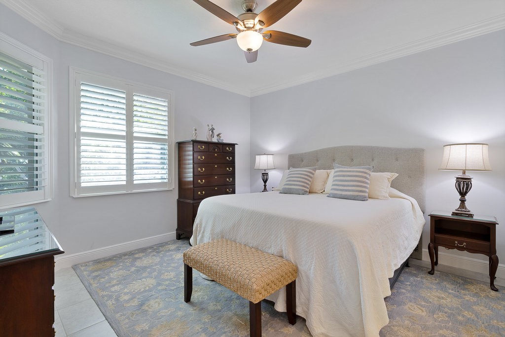 5967 Bella Rosa Lane Vero Beach, FL 32966 - Photo 12 of 30 a bedroom with a bed and a chandelier