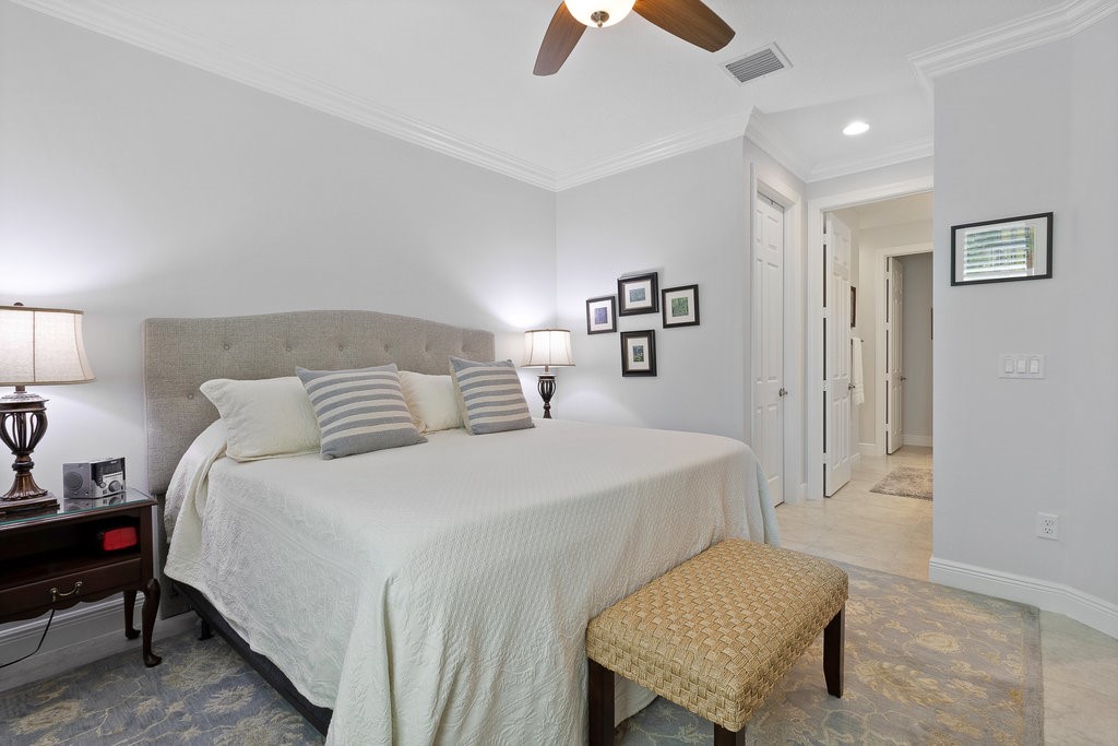 5967 Bella Rosa Lane Vero Beach, FL 32966 - Photo 13 of 30 a bedroom with a bed a lamp and a dresser