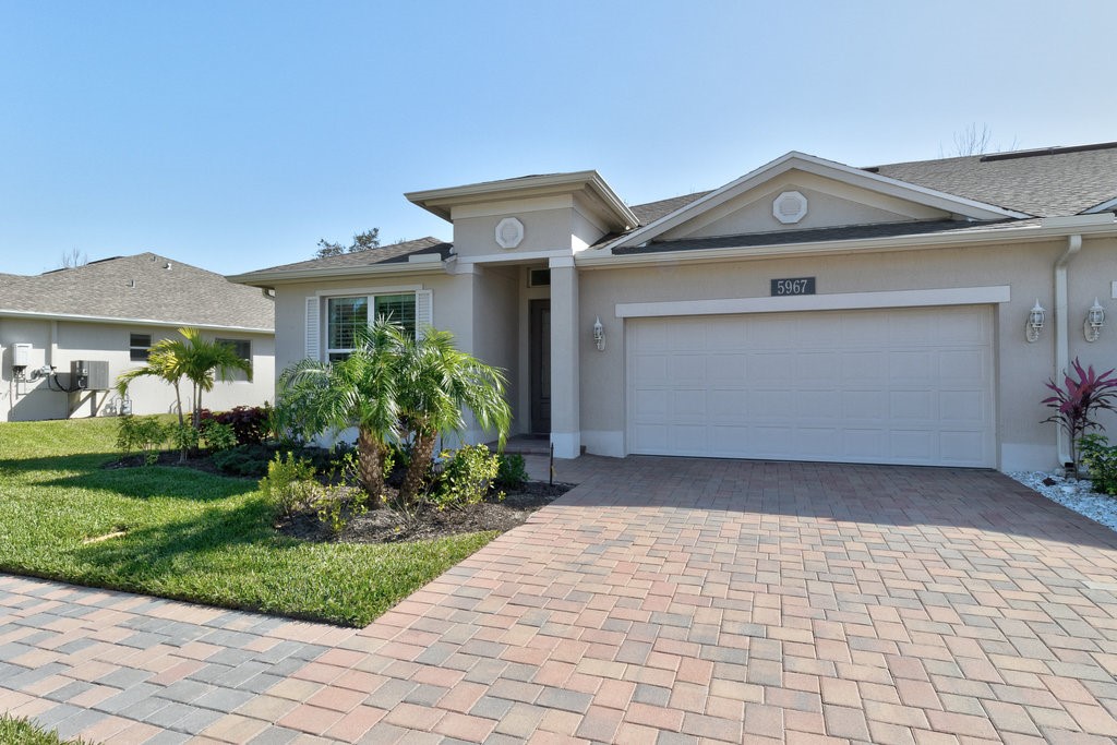 5967 Bella Rosa Lane Vero Beach, FL 32966 - Photo 2 of 30 a front view of a house with garden