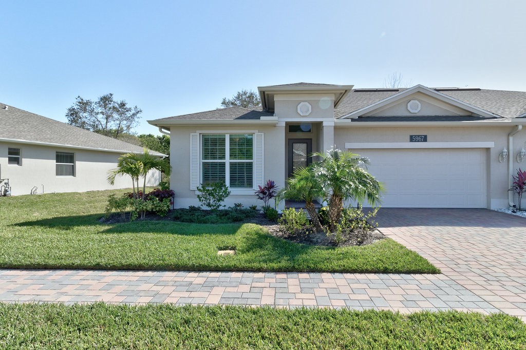 5967 Bella Rosa Lane Vero Beach, FL 32966 - Photo 29 of 30 a front view of a house with a garden