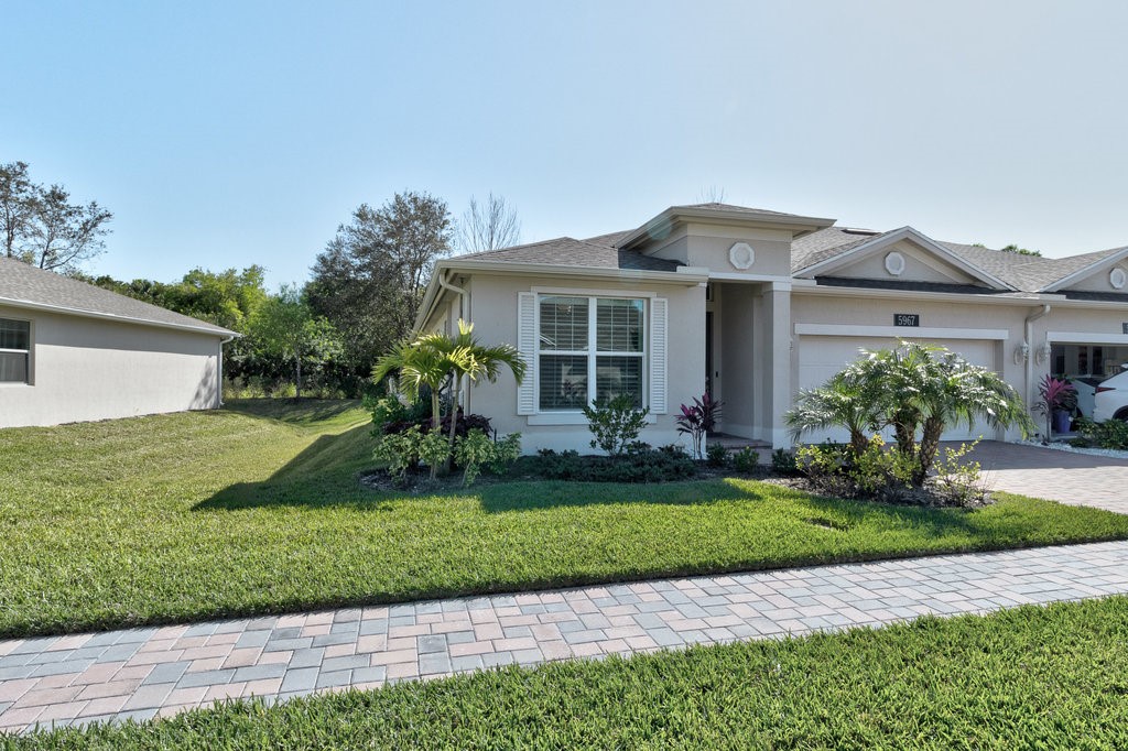 5967 Bella Rosa Lane Vero Beach, FL 32966 - Photo 30 of 30 a front view of a house with a garden and plants