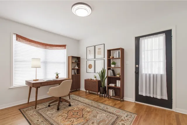 a view of a workspace with wooden floor and a window
