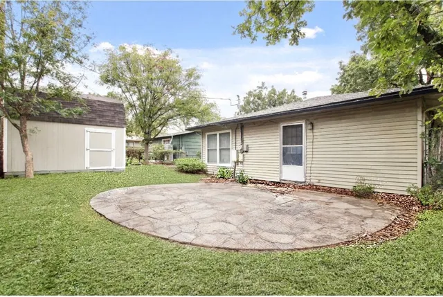 a view of a house with a yard potted plants and large tree