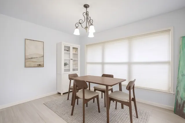 a view of a dining room with furniture a chandelier and wooden floor