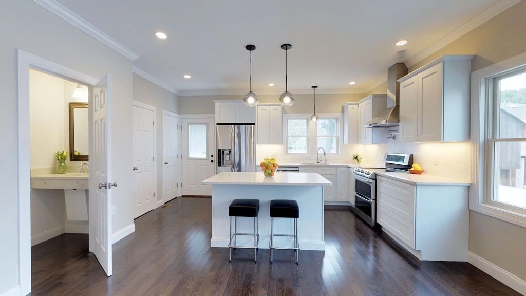 11 Sunset Road, Unit 2 Cambridge, MA 02138 - Photo 12 of 29 a kitchen with kitchen island white cabinets and stainless steel appliances