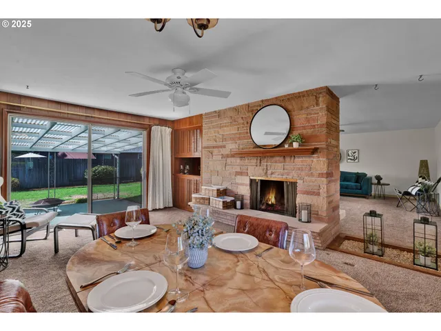a living room with furniture a fireplace and a floor to ceiling window