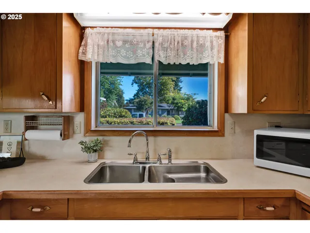 a kitchen with stainless steel appliances a sink a counter space and a window