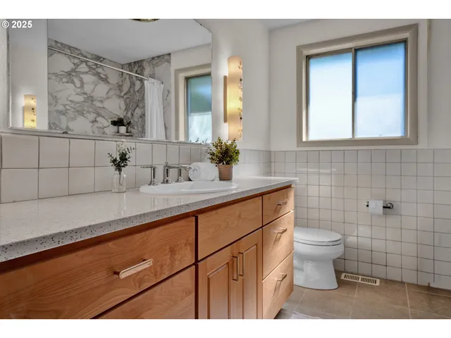 a bathroom with a toilet a sink and mirror