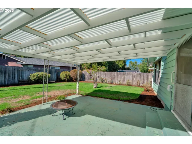 a view of a backyard with wooden fence