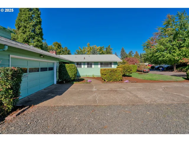 a view of a house with a yard and potted plants