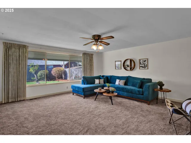 a living room with furniture and a ceiling fan