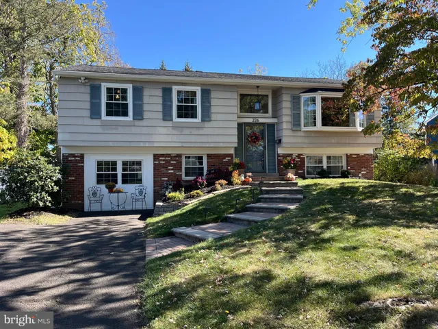 a front view of a house with a yard and trees