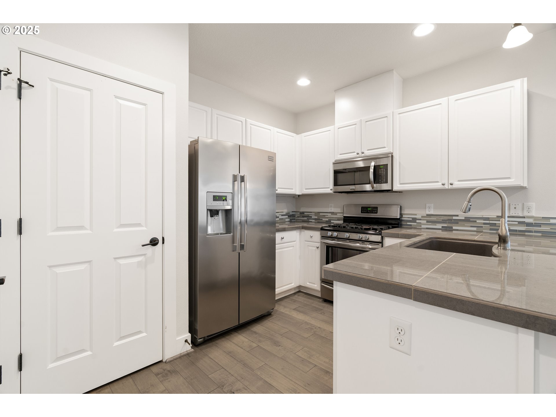 15664 Southwest Ivory Street Beaverton, OR 97007 - Photo 13 of 40 a kitchen with stainless steel appliances a refrigerator a sink a stove a microwave and cabinets