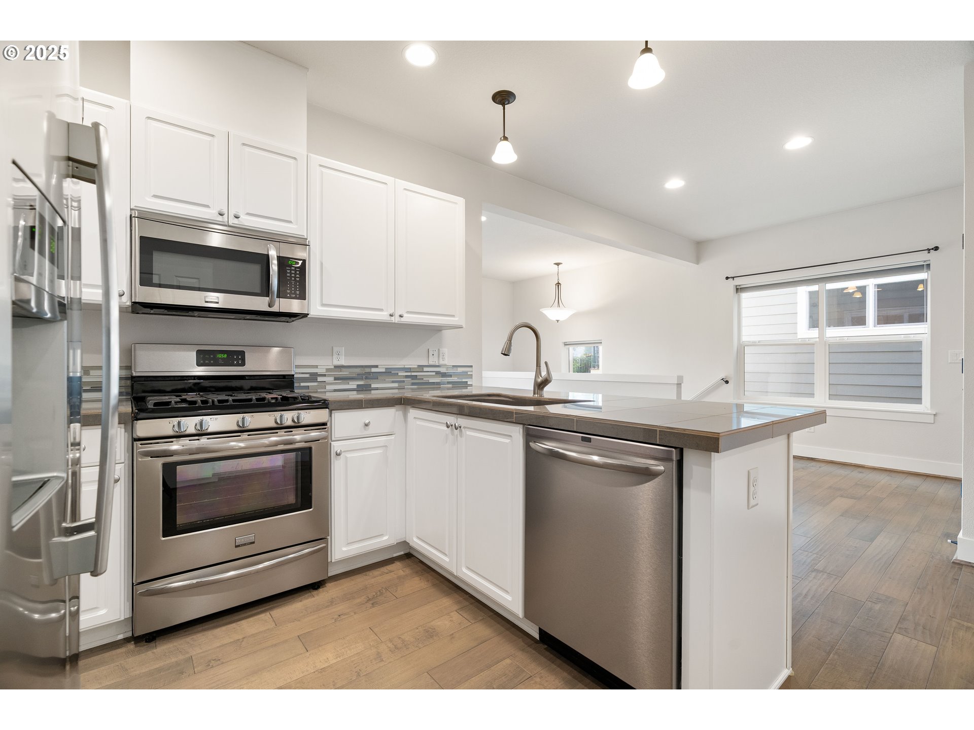 15664 Southwest Ivory Street Beaverton, OR 97007 - Photo 14 of 40 a kitchen with stainless steel appliances granite countertop a stove a sink and a microwave