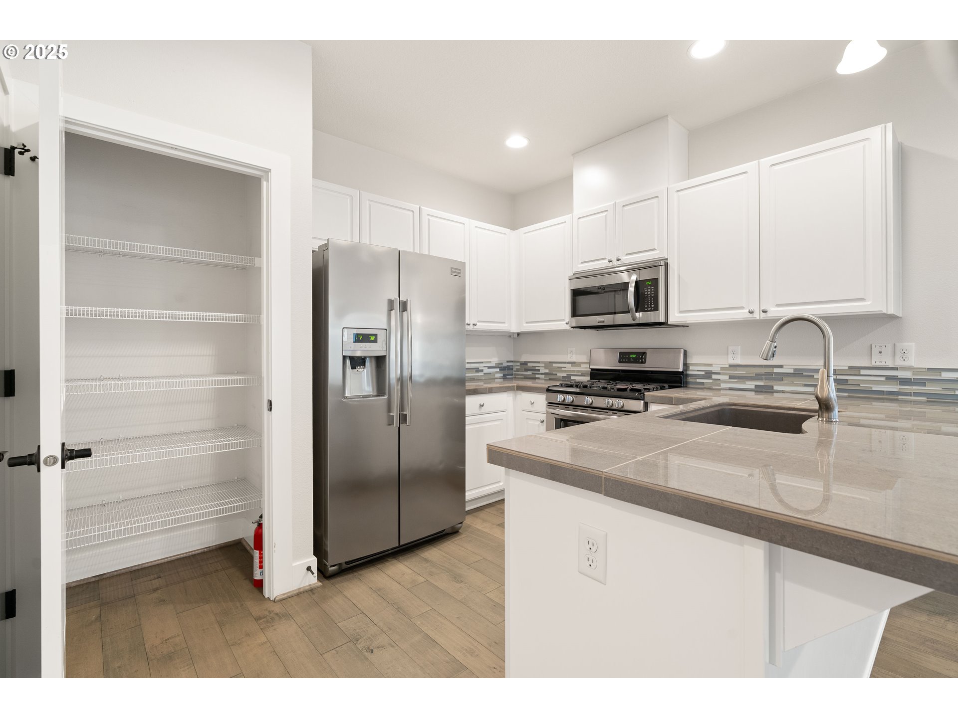 15664 Southwest Ivory Street Beaverton, OR 97007 - Photo 15 of 40 a kitchen with stainless steel appliances a refrigerator sink and microwave