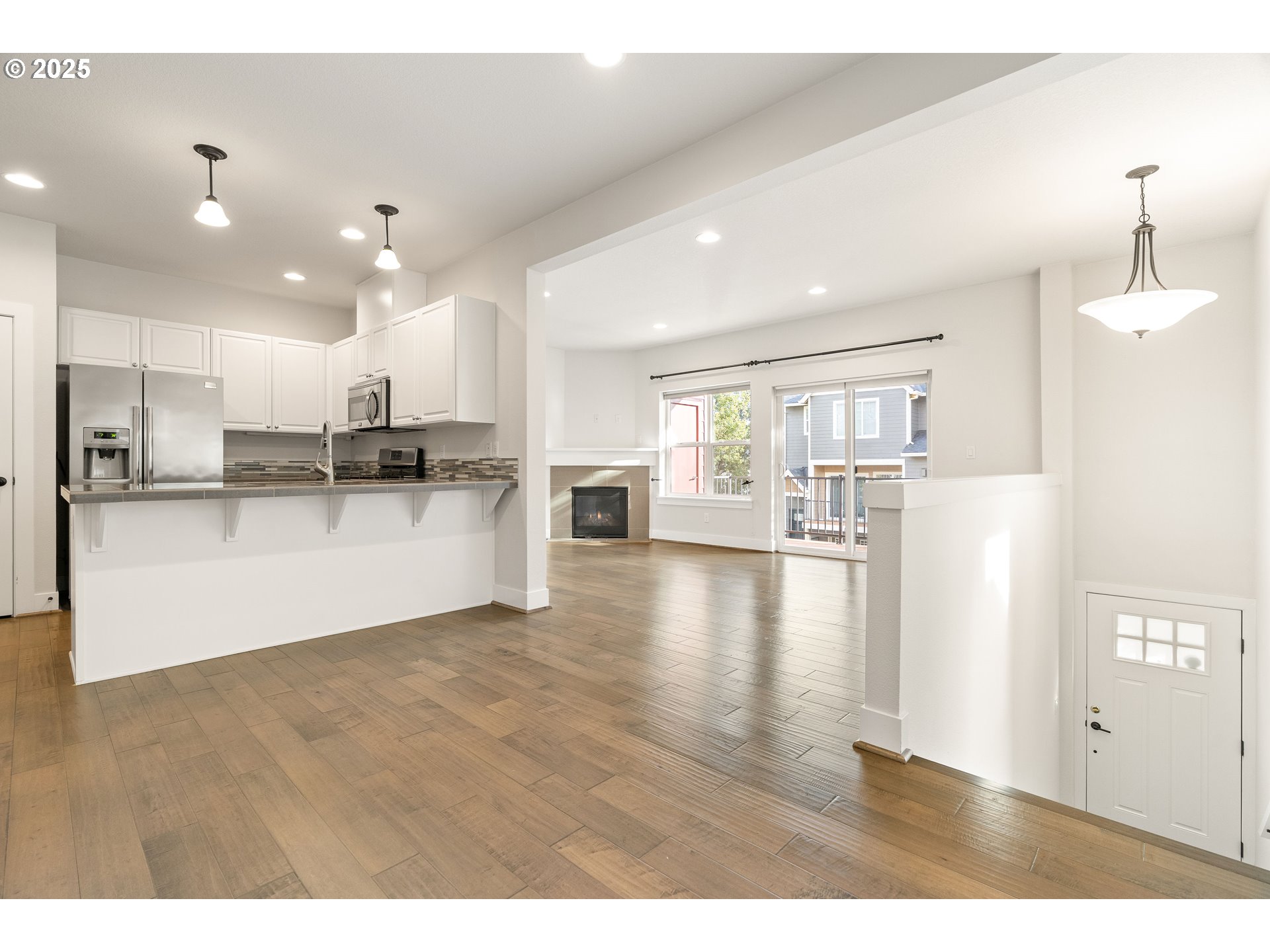 15664 Southwest Ivory Street Beaverton, OR 97007 - Photo 3 of 40 a view of a kitchen with kitchen island wooden floors wooden floor and appliances