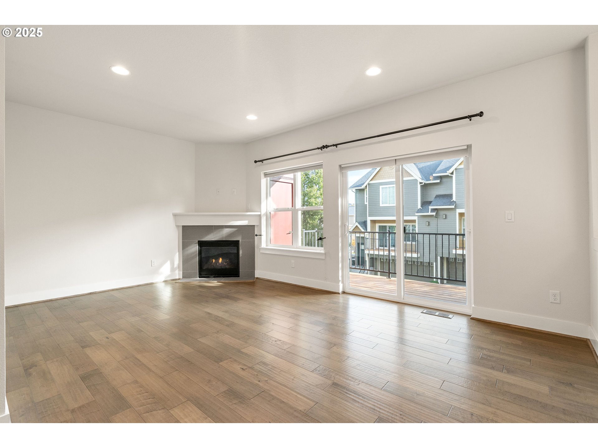 15664 Southwest Ivory Street Beaverton, OR 97007 - Photo 5 of 40 a view of an empty room with wooden floor and a fireplace