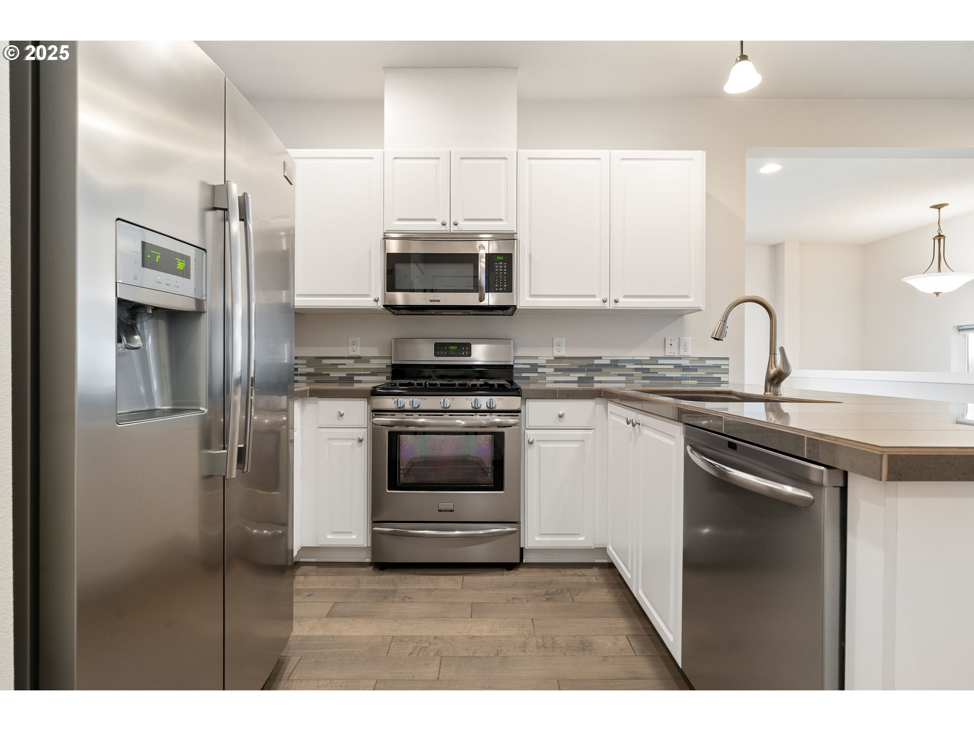 15664 Southwest Ivory Street Beaverton, OR 97007 - Photo 10 of 40 a kitchen with kitchen island granite countertop a stove sink and refrigerator