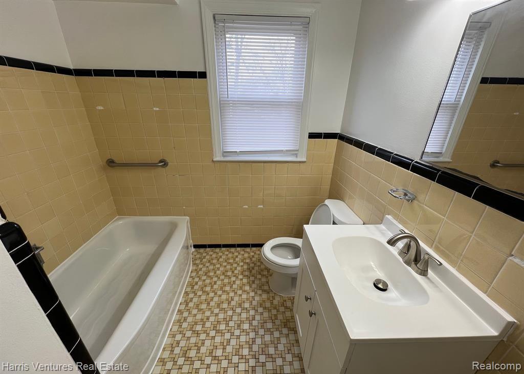 21534 Moross Road Grosse Pointe, MI 48236 - Photo 8 of 16 Bathroom featuring a white vanity with integrated sink, chrome faucet, and mosaic floor tiling