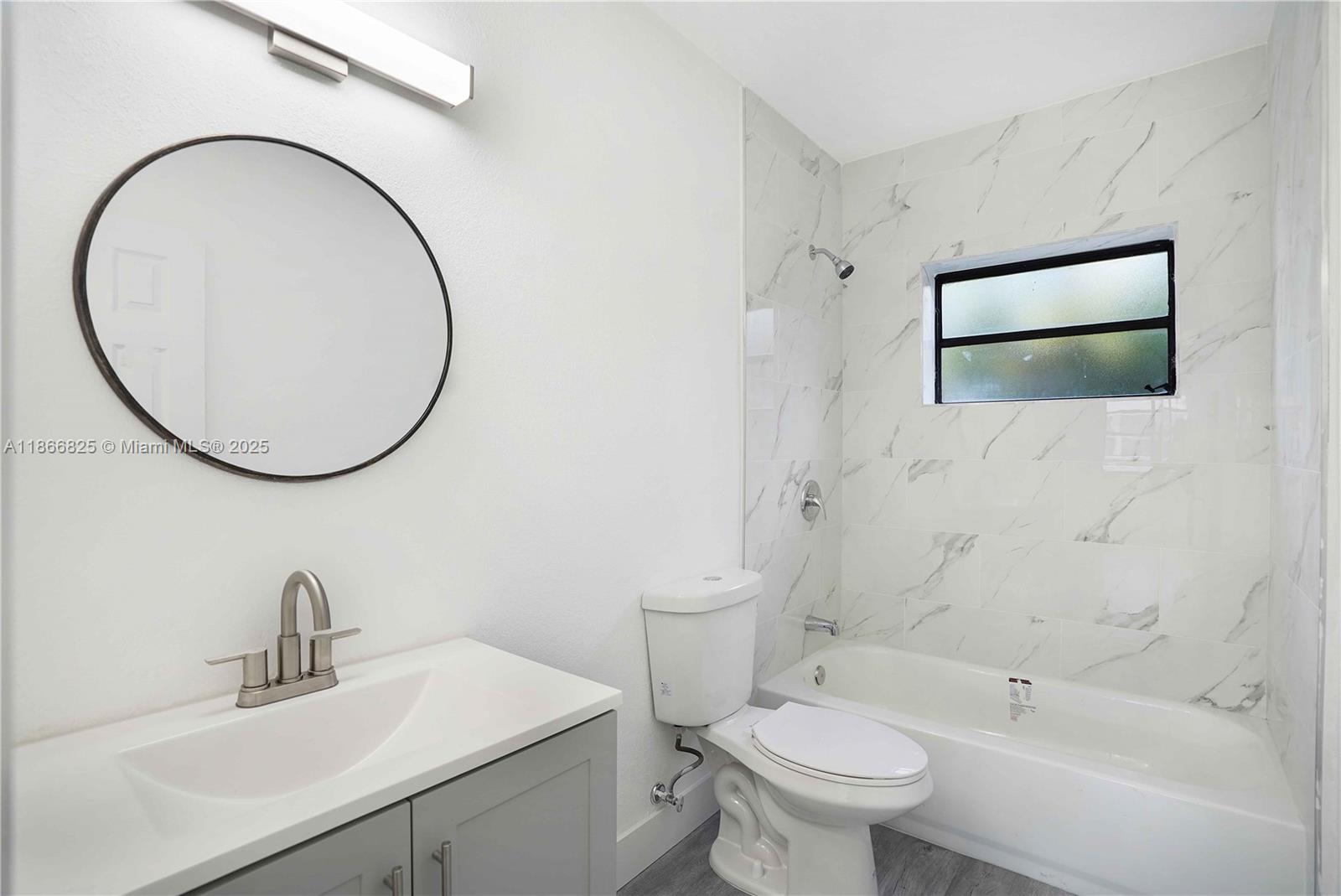 50 East 13th Street Hialeah, FL 33010 - Photo 14 of 38 a bathroom with a sink a mirror a toilet and a shower