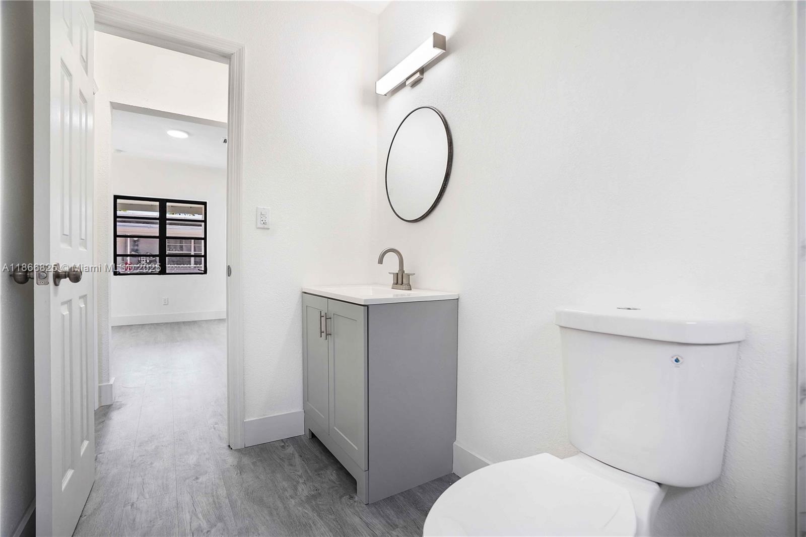 50 East 13th Street Hialeah, FL 33010 - Photo 15 of 38 a bathroom with a toilet a sink and a mirror