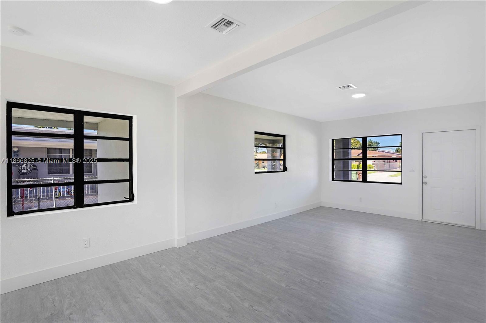 50 East 13th Street Hialeah, FL 33010 - Photo 7 of 38 wooden floor in an empty room with a window