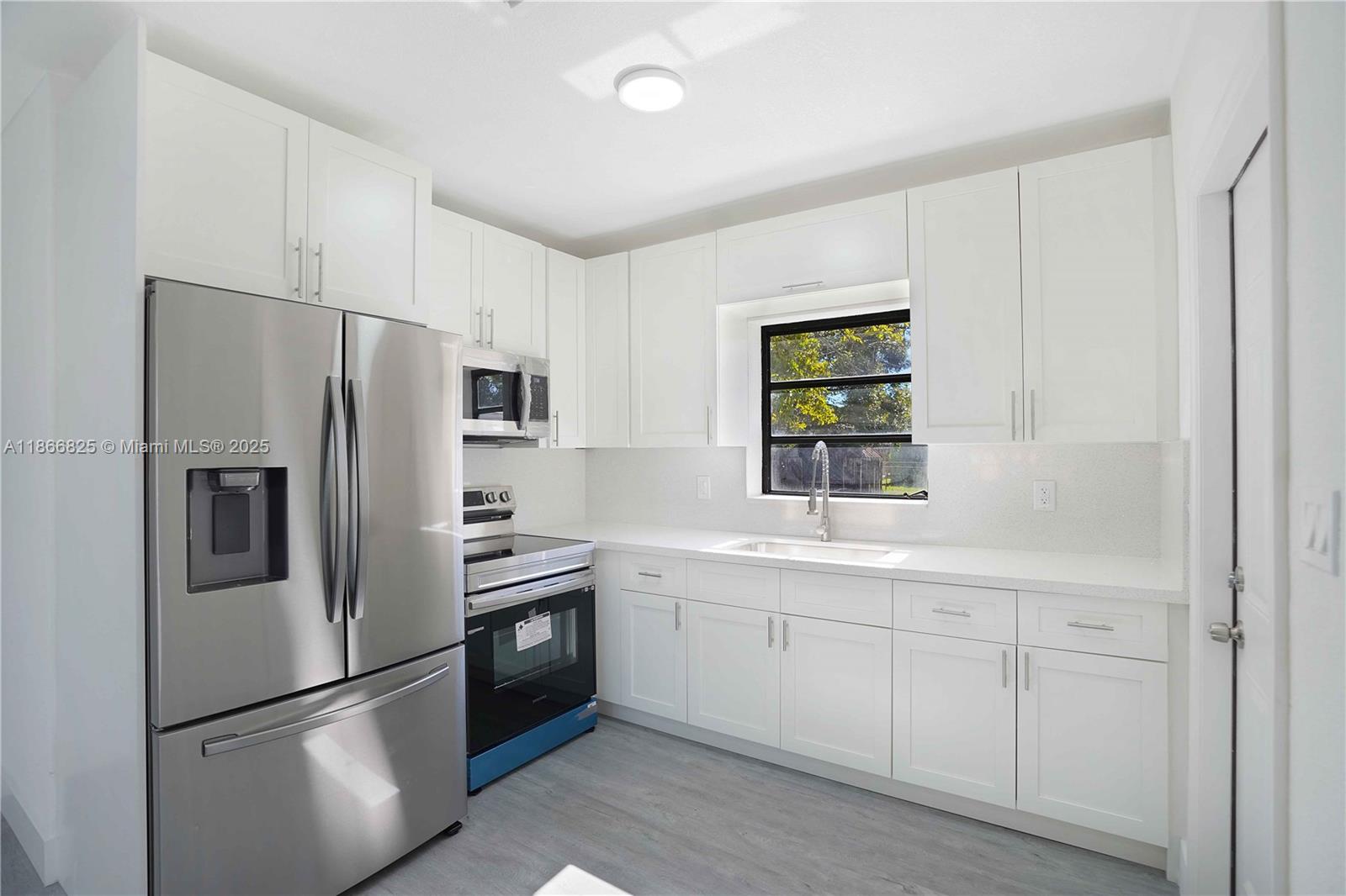 50 East 13th Street Hialeah, FL 33010 - Photo 8 of 38 a kitchen with a refrigerator sink and cabinets