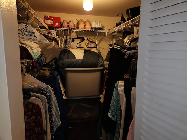 a view of walk in closet with clothes and shoes