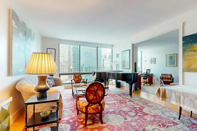 a living room with furniture a rug and a lamp