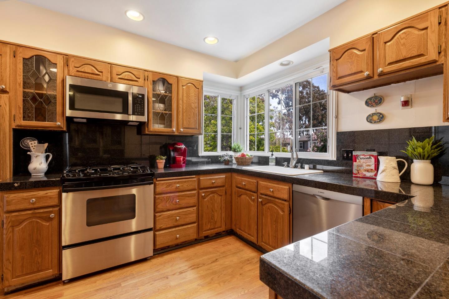 114 Arrowood Lane San Mateo, CA 94403 - Photo 10 of 28 a kitchen with stainless steel appliances granite countertop a stove a sink and a microwave