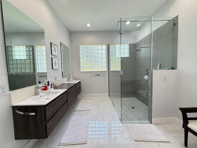 a bathroom with a tub sink shower and mirror